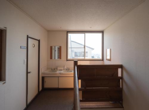 a bathroom with a sink and a window at Nozawa Onsen15M JapowPension粉雪館 in Iiyama