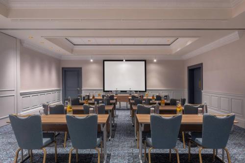 a conference room with tables and chairs and a screen at Tbilisi Marriott Hotel in Tbilisi City