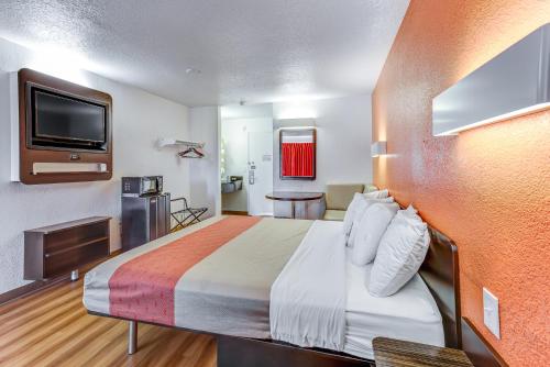 a hotel room with a bed and a flat screen tv at Motel 6-Portland, OR - Tigard West in Tigard