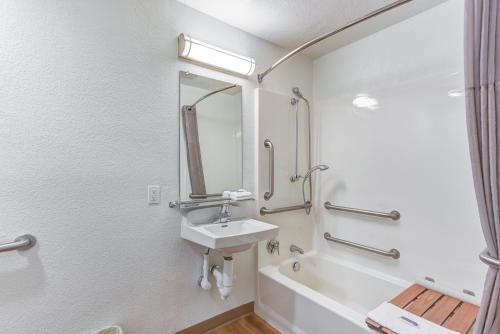 a white bathroom with a sink and a bath tub at Motel 6-Portland, OR - Tigard West in Tigard