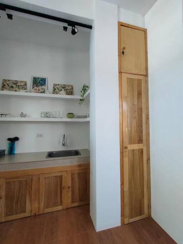 a kitchen with a sink and a wooden door at Absolute Beachfront Studio with Kitchen & Balcony in Boracay