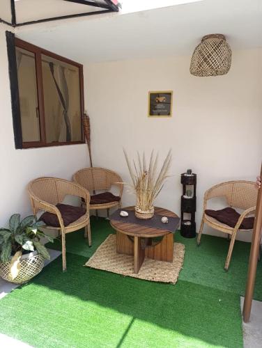 a living room with chairs and a table and green carpet at FAKALI Homestay in Quito