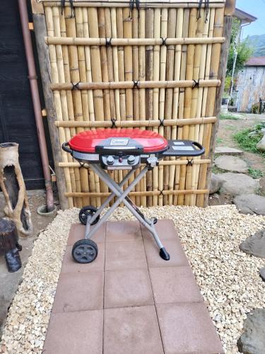 a red and black grill sitting in front of a bamboo wall at 古民家おばあちゃん家Grandma's HouseYugawaraHakoneAtami in Yugawara