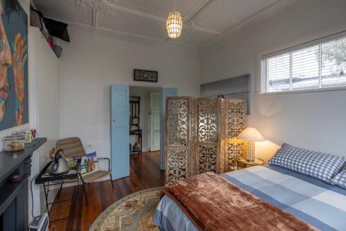 a bedroom with a bed and a table and a lamp at Once upon a Cosy Nook in Dunedin