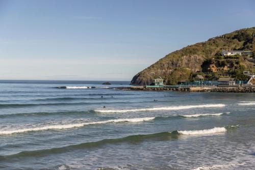 a group of people in the water at the beach at Once upon a Cosy Nook in Dunedin
