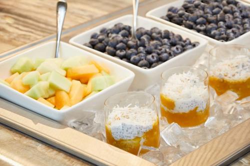 オクラホマシティにあるAC Hotel by Marriott Oklahoma City Bricktownの果物と飲み物が載った食べ物のトレイ