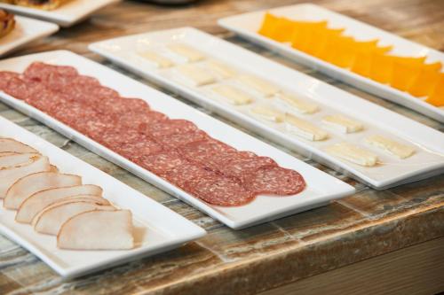 オクラホマシティにあるAC Hotel by Marriott Oklahoma City Bricktownのさまざまな種類の肉とチーズが皿に盛られている