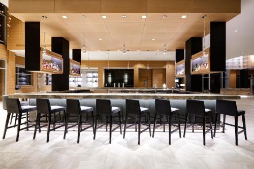 a lobby with a bar with black chairs at AC Hotel by Marriott Oklahoma City Bricktown in Oklahoma City