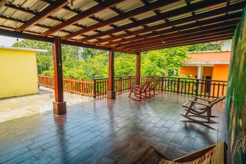 a porch with two chairs and a wooden deck at Zazil Ha Hostel in El Remate