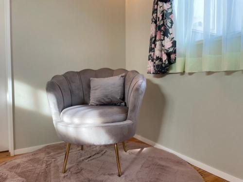 a grey chair with a pillow in a room at ecrin in Awaji