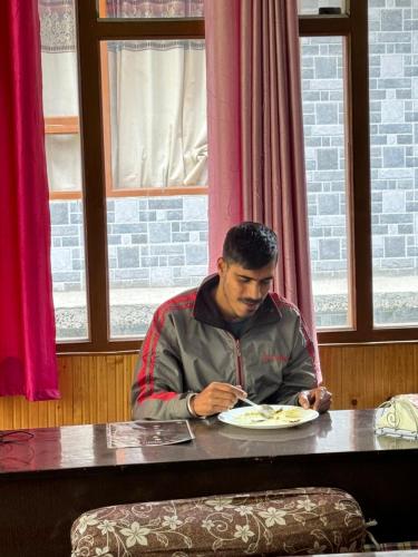a man sitting at a table eating a plate of food at WildFlower in Tosh