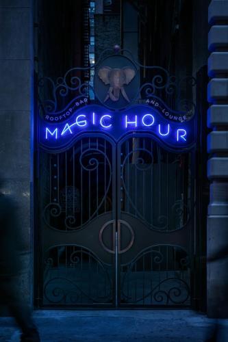 an elephant standing in front of a gate with a magic hour sign at MOXY NYC Times Square in New York
