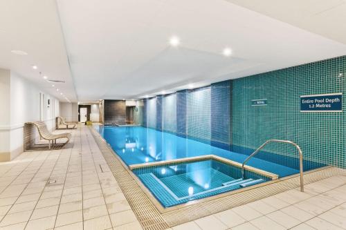 a large swimming pool in a hotel room at Belle Escapes - Beachside Apartment in Glenelg in Glenelg