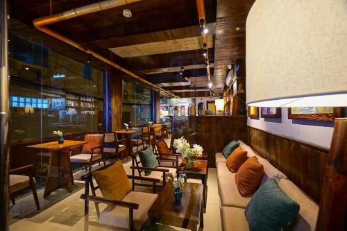 a restaurant with a couch and chairs and tables at Nexus House Nguyen Binh Khiem - Near Saigon Zoo & Botanical Gardens in Ho Chi Minh City