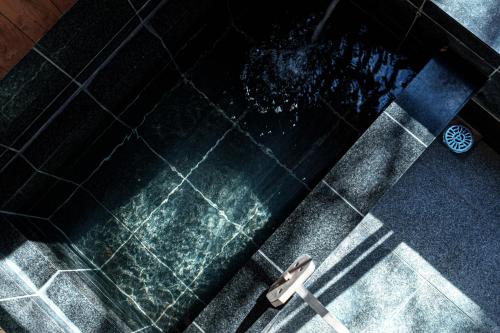 a shower stall with a metal handle in a bathroom at AMAO VILLA 伊豆高原 in Futo