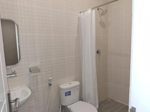 a bathroom with a toilet and a sink at Nio Garden Hotel in Sumbawa Besar