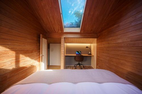 a bedroom with wooden walls and a bed with a window at AMAO VILLA 伊豆高原 in Futo