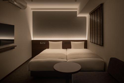 a bedroom with a bed and a table in it at Nest Hotel Tokyo Yaesu in Tokyo