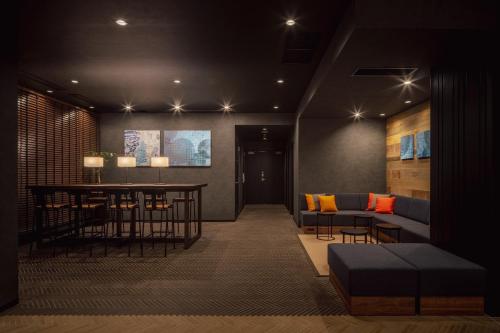 a living room with a couch and a table and chairs at Nest Hotel Tokyo Yaesu in Tokyo