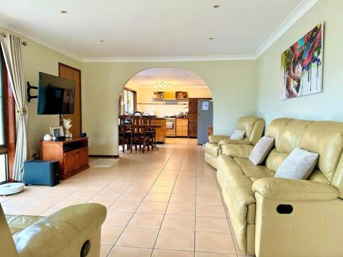 a living room with a couch and a tv at Waterfront Wyuna in Tweed Heads