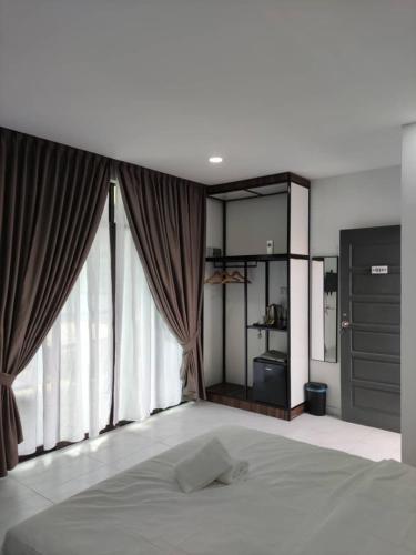 a bedroom with a bed and a large window at Enap Machang in Macang