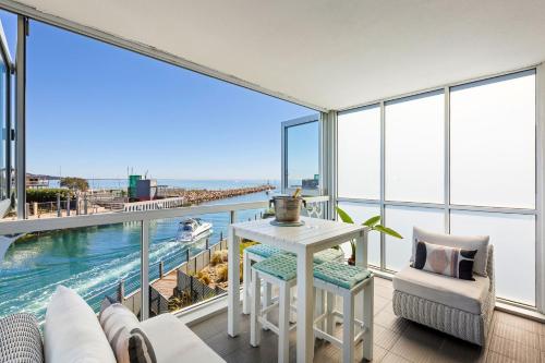 a living room with a view of the water at Azure Bliss - Majestic Apartment on the Water in Safety Beach