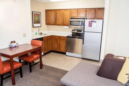 a kitchen with a table and a white refrigerator at Residence Inn by Marriott Rocky Mount in Rocky Mount