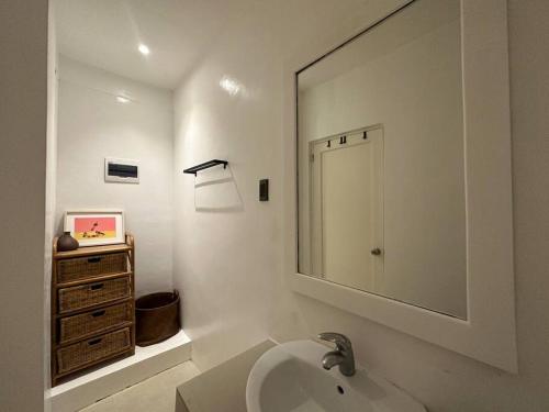 a bathroom with a sink and a mirror and a dresser at Absolute Beachfront Apartment With Kitchen in Boracay