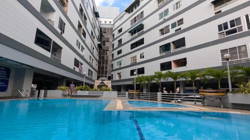 a large swimming pool in front of two buildings at Pattaya Hagone Condotel in Pattaya South