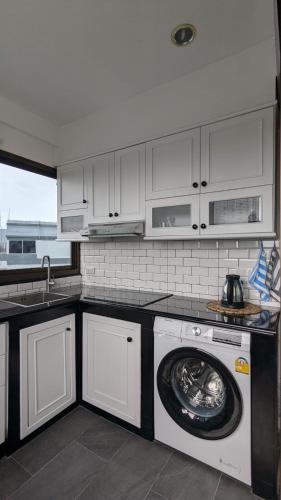 a kitchen with a washing machine and a sink at Pattaya Hagone Condotel in Pattaya South