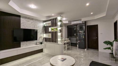 a living room with a flat screen tv on a wall at Pattaya Hagone Condotel in Pattaya South