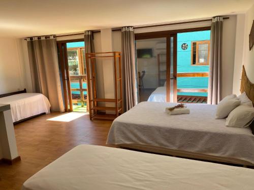 a hotel room with two beds and a balcony at FLATS SHALON - MORRO DE SÃO PAULO in Morro de São Paulo
