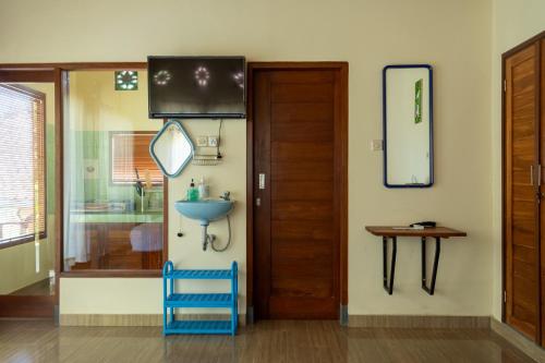 a bathroom with a blue chair and a mirror at Pondok Hari Baik in Balian