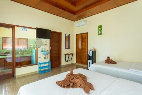 a hotel room with two beds and a bathroom at Pondok Hari Baik in Balian
