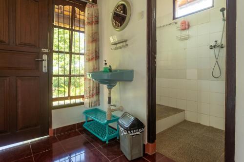 a bathroom with a blue sink and a shower at Pondok Hari Baik in Balian