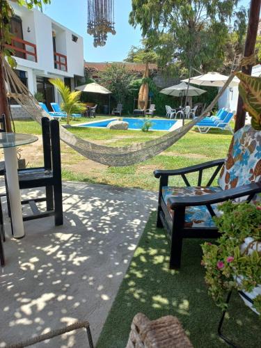 a hammock in front of a resort with a pool at Montemar Apart Hotel - Playa Huanchaco in Huanchaco