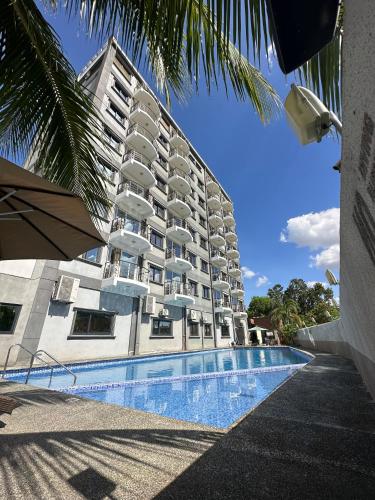 a large building with a swimming pool in front of it at PUNTA CLARK HOTEL in Clark