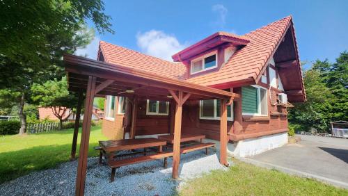a wooden cabin with a bench in front of it at 보성녹차리조트 in Boseong