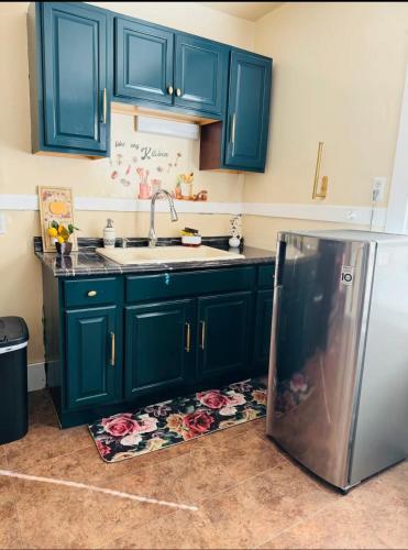 a kitchen with blue cabinets and a stainless steel refrigerator at Beautiful 3 bed room apartment in Buffalo