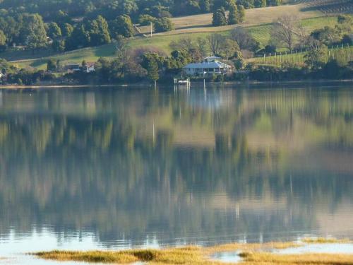 a large body of water with a house in the background at Haven House - River Edge Apartment in Rosevears