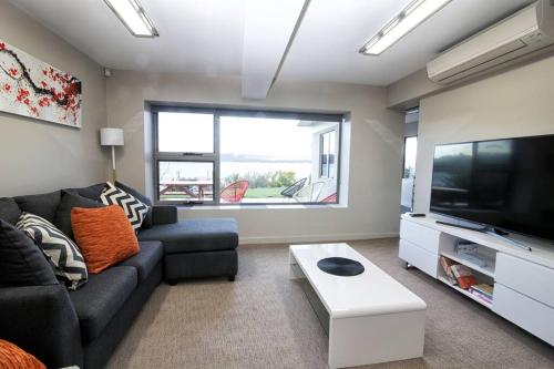 a living room with a couch and a flat screen tv at Haven House - River Edge Apartment in Rosevears