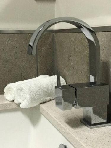 a bathroom sink with a toilet paper dispenser on a counter at Haven House - River Edge Apartment in Rosevears