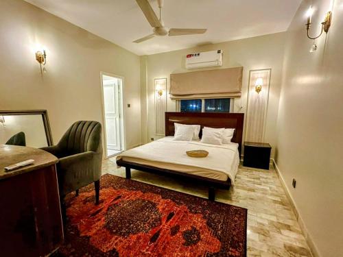 a bedroom with a bed and a couch and a chair at Oceanfront Oasis - Steps to Dolmen Mall in Karachi