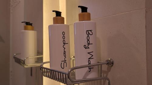 two white bottles in a holder in a bathroom at Oceanfront Oasis - Steps to Dolmen Mall in Karachi