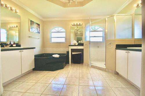 a bathroom with a shower and a bath tub at Banana Tree Casa in Eden
