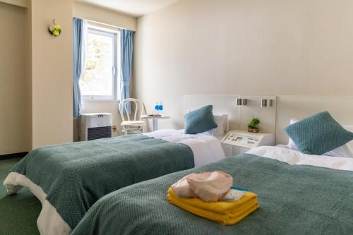 a bedroom with two beds with green and white at 雪场缆车站旁 Hotel Justice-Ski IN Ski OUT-独立卫浴 in Seki