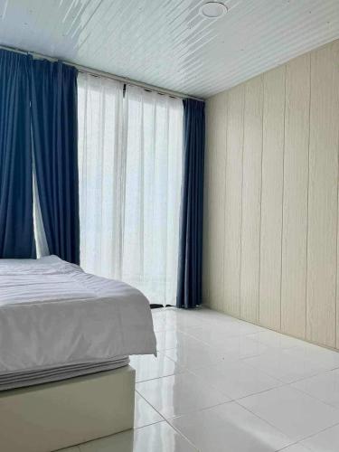 a bedroom with a bed and blue drapes at วิมานหมอก ภูทับเบิก in Ban Maeo Thap Boek