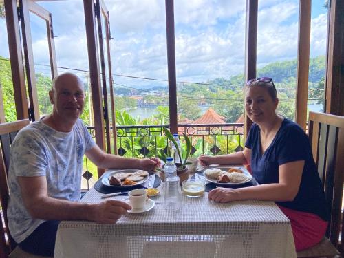 a man and a woman sitting at a table with food at Sesatha lake Kandy in Kandy