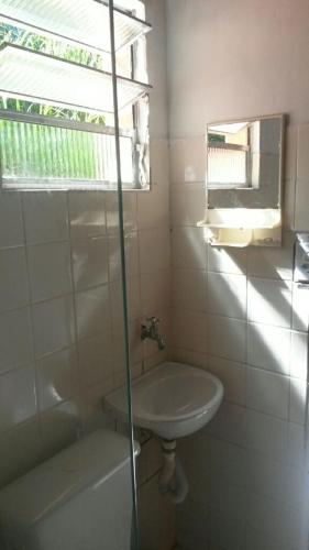 a bathroom with a sink and a tub and a window at Chalé do Saulo in Ilhabela