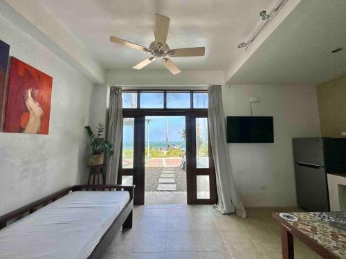 a living room with a ceiling fan and an open door at Two Bedroom Affordable Beach Front House in Boracay